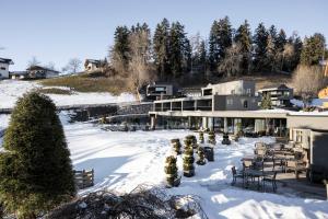 un edificio nella neve con tavoli e sedie di Hotel Viertler a Avelengo