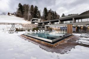 een huis met een zwembad in de sneeuw bij Hotel Viertler in Avelengo