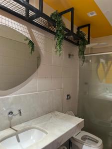 a bathroom with a sink and a toilet and a mirror at Belô Hostel in Belo Horizonte