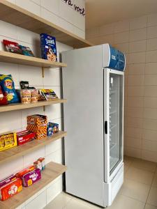 a white refrigerator in a room with shelves at Belô Hostel in Belo Horizonte