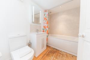 a bathroom with a toilet and a sink and a tub at Central Kendal Georgian Home with private courtyard & free parking in Kendal +20 photos