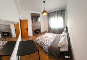 a bedroom with two beds and a table and a window at VILLAGE SINTRA gh in Sintra