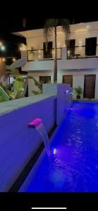 a swimming pool with purple lights in a building at Cavite’s Cozy Villa in Imus