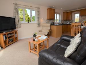 a living room with a couch and a table at 1 bed in Bude SCADG in Poughill