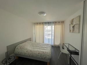 a small bedroom with a bed and a window at Appartement résidentiel Longjumeau in Longjumeau