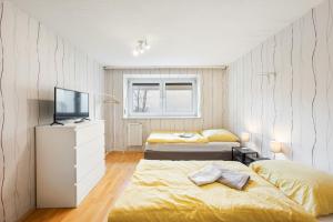 a bedroom with two beds and a television in it at MONTEURWOHNUNG Gingen an der Fils RAUMSCHMIDE Apartments 