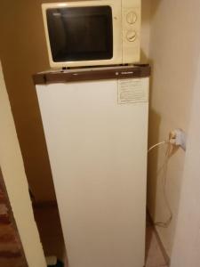 a microwave sitting on top of a refrigerator at Departamentos Haiti in Bahía Blanca