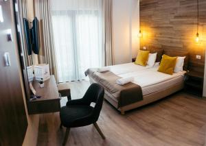 ein Hotelzimmer mit einem Bett und einem Stuhl in der Unterkunft Amethyst in Sovata