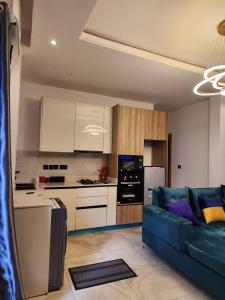 uma sala de estar com um sofá azul e uma cozinha em City View Apartments em Lekki