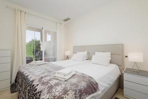 イスタンにあるApartment Balcones del Lagoの白いベッドルーム(大型ベッド、タオル付)