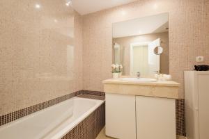 a bathroom with a tub and a sink and a bath tubermott at Apartment Balcones del Lago in Istán