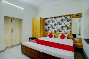 a bedroom with a large bed with red pillows at OYO Dayal Heritage in Hazārībāg