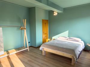 1 dormitorio con 1 cama con paredes azules y suelo de madera en OceanGroupApartments Mantova Cozy House, en Mantua