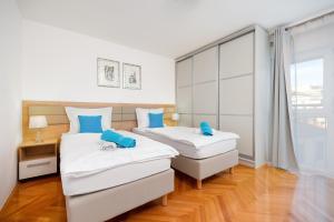 two beds in a room with a window at Apartment Mares in Split