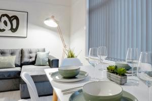 uma sala de estar com uma mesa com pratos e copos de vinho em Stylish 2 bedroom flat - 15 minutes to Liverpool City Centre em Birkenhead