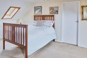 a bedroom with a wooden bed and a door at Host & Stay - Freshwater River View in Dunoon