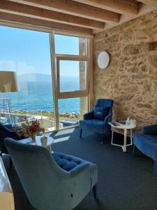 a living room with a view of the ocean at Hotel Tematico Do Banco Azul in Finisterre