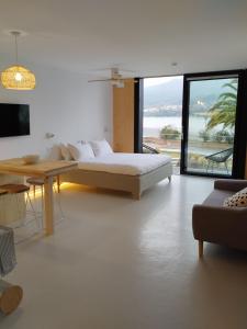a white room with a bed and a table and a couch at Maison Laida in Ibarrangelu