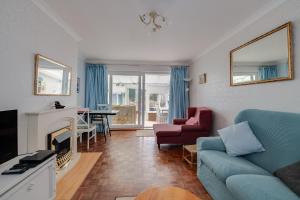 een woonkamer met een bank en een open haard bij Coastal Haven in Felpham