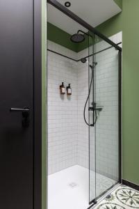 La salle de bains est pourvue d'une douche avec une porte en verre. dans l'établissement Domaine de Bellescize, à Chasselay