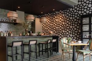 um restaurante com um bar com cadeiras e mesas em Domaine de Bellescize em Chasselay