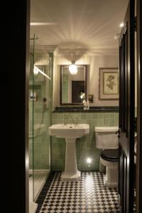 La salle de bains est pourvue d'un lavabo, de toilettes et d'une douche. dans l'établissement Bedford Arms Hotel, à Rickmansworth