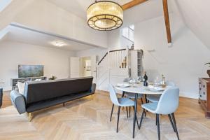 a piano in a living room with a table and chairs at Luxury 3 Bed Flat in Kensington in London