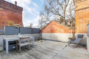 a patio with a table and chairs and a fence at Luxury 3 Bed Flat in Kensington in London
