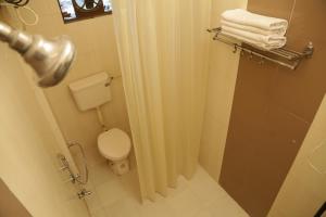 a bathroom with a toilet and a shower with towels at Hotel Meenakshi Udaipur - Family Preffered Hotel in Udaipur