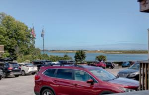 a red car parked in a parking lot near the water at Aspinquid Resort in Ogunquit