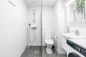 a bathroom with a shower and a toilet and a sink at SPOT Apartments Hämeenlinna in Hämeenlinna