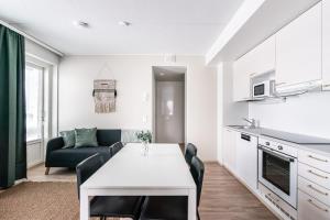 a kitchen and living room with a table and a couch at SPOT Apartments Hämeenlinna in Hämeenlinna