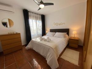 a bedroom with a white bed with a ceiling fan at M&H Torremolinos in Torremolinos