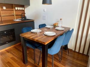 un tavolo in legno con sedie blu e una cucina di Olimian Retreat Rosa 421 a Podcetrtek
