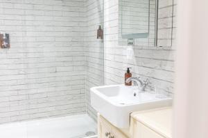 Baño blanco con lavabo y espejo en Chequers Lodge- Dalton-in- Furness- Self check in en Dalton in Furness