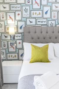 a bedroom with a wall of framed bird pictures at Chequers Lodge- Dalton-in- Furness- Self check in in Dalton in Furness