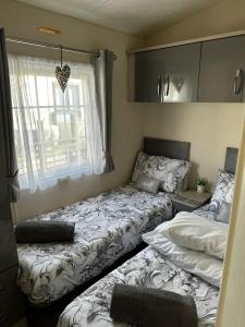 een slaapkamer met 2 bedden en een raam bij Yealands Delight in Warton