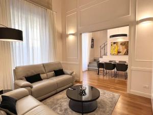 ein Wohnzimmer mit einem Sofa und einem Tisch in der Unterkunft Charming Penthouse near Duomo in Florenz