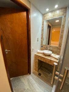 a bathroom with a sink and a mirror at Adobe Suites in Salta