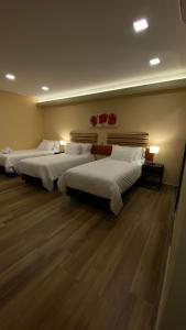 Duas camas num quarto com pisos de madeira em Adobe Suites em Salta
