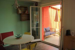 a room with a table and a table and a chair at Camping "le Pécos" appartement confort 5 personnes in Grandson