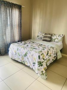 1 dormitorio con 1 cama con edredón de flores en Greenstone Ridge en Lombardy East