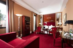 Habitación de hotel con muebles de color rojo y comedor. en Hotel Lord Byron - Small Luxury Hotels of the World en Roma