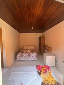 een slaapkamer met een bed en een houten plafond bij Pousada da Barra in Barra Grande