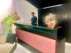 a man standing behind a counter in a room at Hotel Nathaliya in Seeduwa