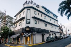 Un alto edificio bianco all'angolo di una strada di The Looking Glass Hotel a San Juan