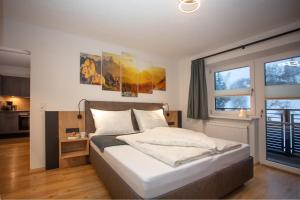 Un dormitorio con una cama grande y una ventana en Natura Aparts, en Stanzach