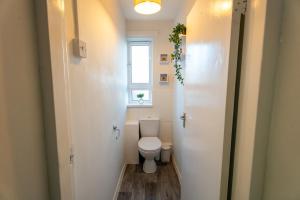 a small bathroom with a toilet and a window at Cosy Flat 10 mins to Central London sleeps 5 in London