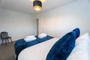 a bedroom with a large bed with blue pillows at Cosy Flat 10 mins to Central London sleeps 5 in London