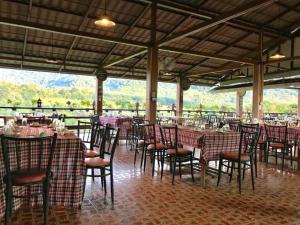 comedor con mesas y sillas y vistas en Phurua Bussaba Resort & Spa, en Loei